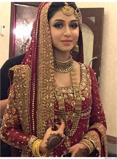 a woman in a red and gold bridal outfit