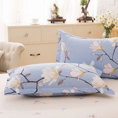 two pillow cases with flowers on them in front of a white dresser and windowsill