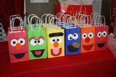 the sesame street characters are lined up on the table with their paper bags in front of them