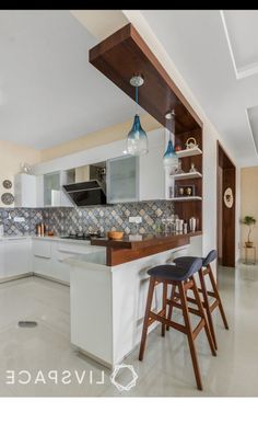 a kitchen with two bar stools next to an island in the middle of it