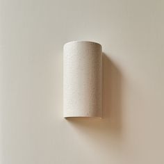 a white wall light mounted on the side of a wall