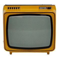 an old yellow television sitting on top of a table