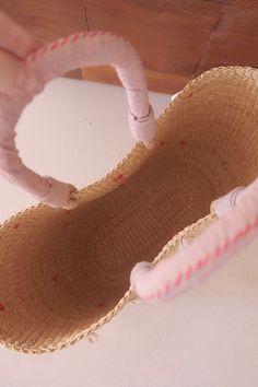 a close up of a stuffed animal in a straw hat on a wooden table top