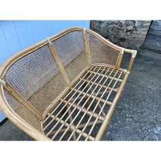 a rattan chair sitting on the ground next to a wall