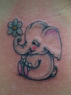 an elephant with a flower in its trunk on the back of a woman's stomach