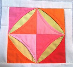 an orange, pink and yellow piece of fabric on a white cloth with stitching