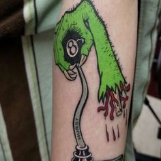 a person with a green and black tattoo on their arm that has a drawing of a hand holding a computer mouse