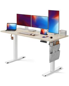 three computer screens sitting on top of a desk with two laptops next to them