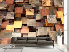 a couch sitting in front of a wall covered in wooden squares and rectangles