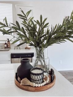 a vase with some plants in it on a tray