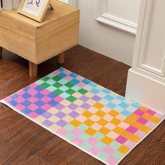 a multicolored rug on the floor next to a wooden table with a clock