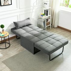 a living room with a couch and coffee table on the floor in front of a window