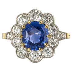 Ring in 18 karat yellow gold and platinum, eagle and dog heads hallmarks. Modern daisy ring, it is composed of a slightly oval blue sapphire set with claws and surrounded by 10 brilliant-cut diamonds in millegrain setting. 2 x 2 diamonds are set on either side of the head on the start of the ring. Total weight of the sapphire : 2,38 carats approximately. Total weight of the diamonds : 1.93 carats approximately. Height : 15.5 mm approximately, width : 14 mm approximately, thickness : 6.5 mm appro Saphiner Ring, Timeless Engagement Ring, Victorian Engagement Rings, Platinum Diamond Engagement Rings, Daisy Ring, Blue Sapphire Diamond, Gold Ring Sets, Fancy Diamonds, Diamond Gold