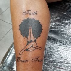 a woman with a tattoo on her leg that says faith and an afro tree behind her