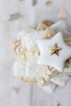 some cookies with white icing and gold stars on them