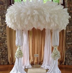 the wedding arch is decorated with white flowers and tulle for an elegant touch to the ceremony