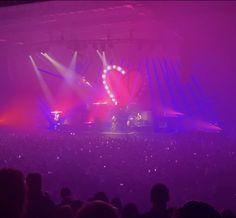 the stage is lit up with purple and red lights