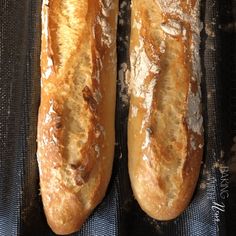 two loaves of bread sitting on top of a black cloth