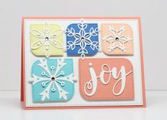 a card with snowflakes on it and the word joy written in different colors