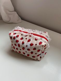 A strawberry shortcake pouch with a beige strawberry print on the outside and a red polka dot print on the inside. It includes some beige lace, a red zipper, and some beige bias tape on the inside of the pouch. Green Bay Packers Shirts, Strawberry Print, Bias Tape, Red Polka Dot, Toiletry Storage, Polka Dot Print, The Pouch, Strawberry Shortcake, Dot Print