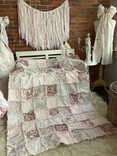 a baby crib is covered in pink and white quilts