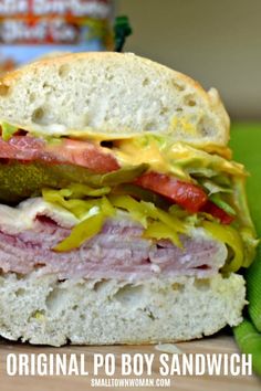 a close up of a sandwich with meat and vegetables on it next to a can of soda