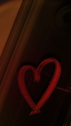 a red heart drawn on the side of a wall in front of a light fixture