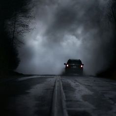 a car driving down a road in the dark