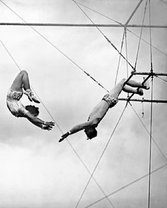 three people are performing acrobatic tricks in the air while one person is upside down