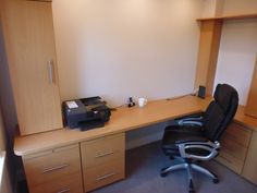 an office chair sitting in front of a desk with a printer on top of it