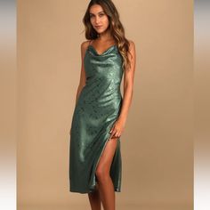 a woman in a green dress posing for the camera with her legs slited up