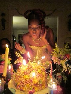 a woman blowing out candles on a cake