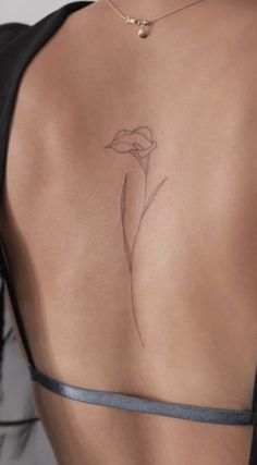 a woman's back with a flower tattoo on it