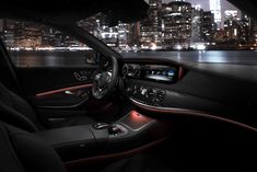 the interior of a car with city lights in the background