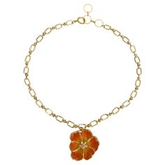 an orange flower on a gold chain bracelet