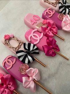 pink and black decorated toothpicks with bows on them sitting on top of each other