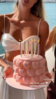 a woman holding a cake with candles on it