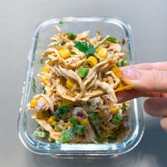 a person is picking up some food from a plastic container