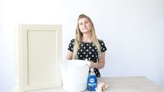 a woman sitting at a table with a bucket