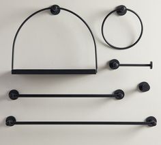 three black bathroom accessories hanging on the wall next to each other with circles and bars