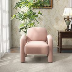 a living room with a pink chair next to a potted plant on a table