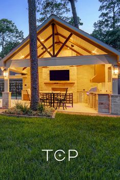 an outdoor kitchen and dining area is lit up at night with the words top above it