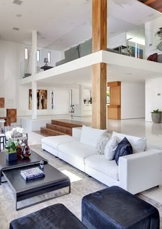 a living room filled with white furniture and lots of wooden beams on the ceiling above