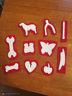 some cut out dogs and bones on a wooden table with white icing in the shape of hearts