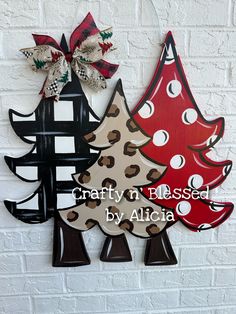 two wooden christmas trees hanging on a brick wall with the words crafty n'blissed by alicia