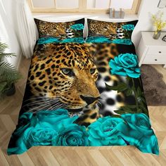 a leopard and blue roses on a bed with matching comforter covers, in a room