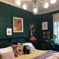 a bedroom with green walls and pictures on the wall