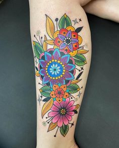 a colorful flower tattoo on the leg