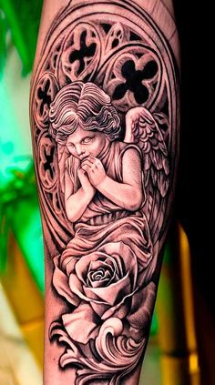 an angel with roses on his arm is shown in black and grey ink, while the background