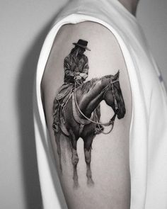 a black and white photo of a man on a horse wearing a hat, sitting on the back of a horse